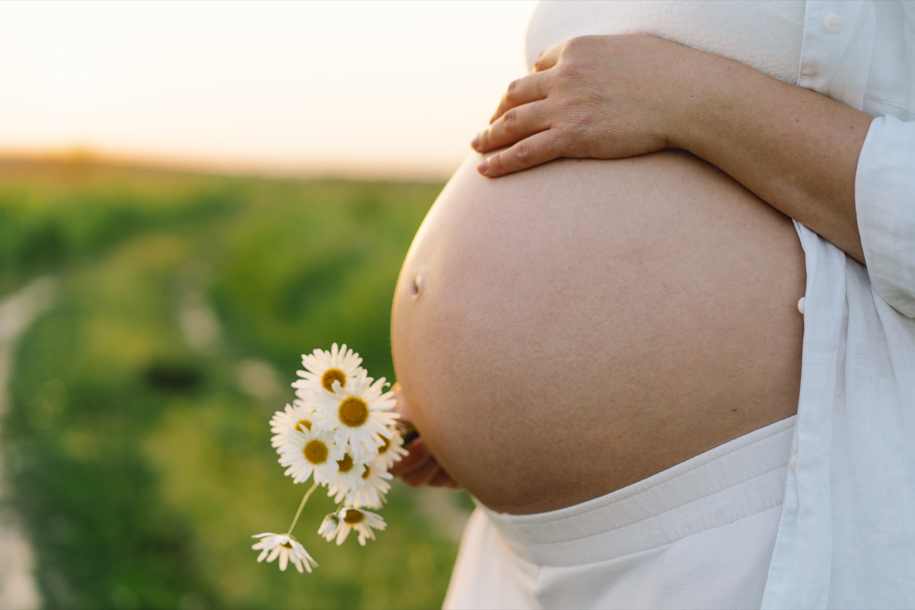 Femme enceinte, mains posées sur son ventre